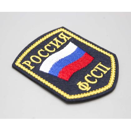Где купить Шеврон вышитый РОССИЯ ФССП, темно-синие поле ( шелк ) без липучки в Москве недорого с доставкой по России